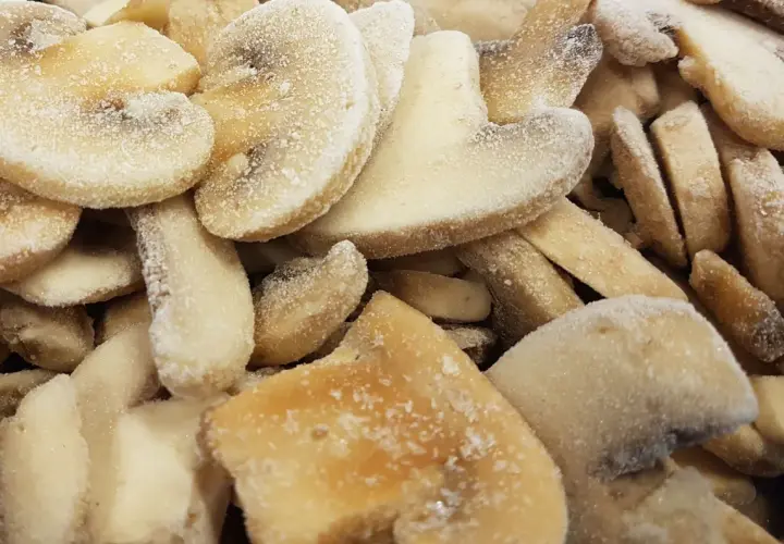 Zamrożone plasterki bananów, posypane cukrem. Czy pieczarki można mrozić? Tak, ale te wyglądają jak słodka przekąska.