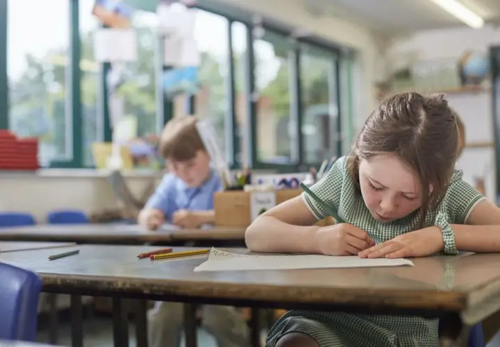Dziewczynka z piegami skupiona na rysowaniu. Ciekawe, od jakiej średniej jest 4, którą właśnie narysowała?