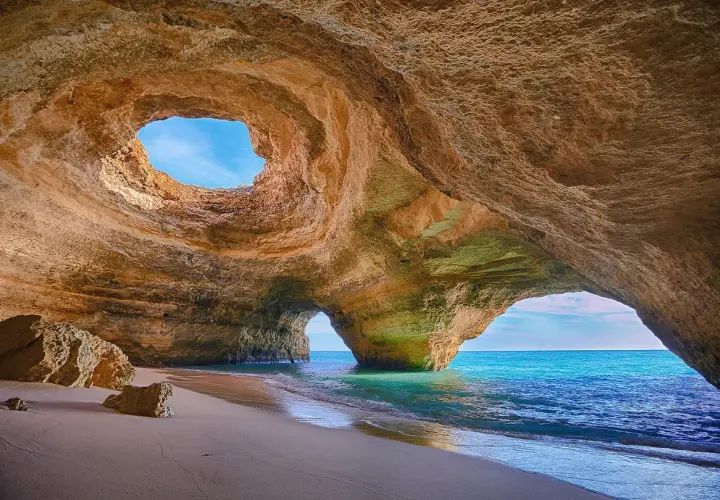 Cueva marina con arco natural y playa de arena. Un lugar perfecto donde viajar en noviembre para disfrutar del sol y el mar.