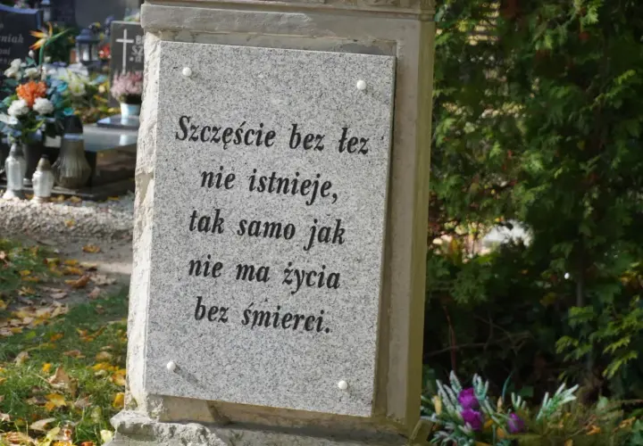 Kamienna płyta z cytatem na cmentarzu, miejsce na urny. "Szczęście bez łez nie istnieje, tak samo jak nie ma życia bez śmierci.