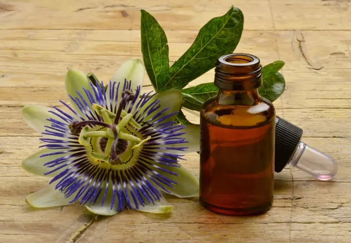 Fiore di passiflora e boccetta di tintura madre, per scoprire le sue proprietà benefiche.