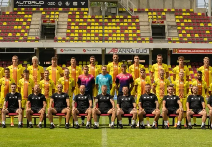 Drużyna Korona Kielce zawodnicy pozują do zdjęcia na tle stadionu.