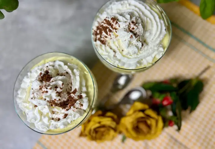 Dwa pucharki z kremem mascarpone, udekorowane bitą śmietaną i kakao. Idealne, gdy zastanawiasz się, co zrobić z mascarpone.