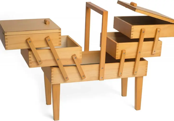 Un costurero madera grande con múltiples compartimentos y patas, ideal para organizar hilos, agujas y otros accesorios de costura.