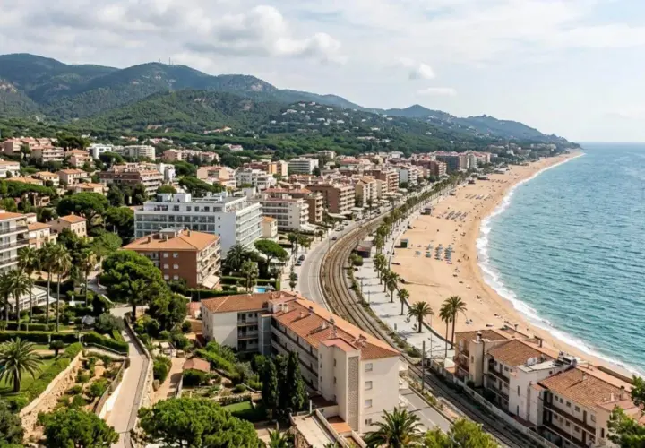 Vista aérea de una ciudad costera con edificios, playa y mar azul. Las **zenhotels opiniones** de este lugar sugieren una estancia relajante.