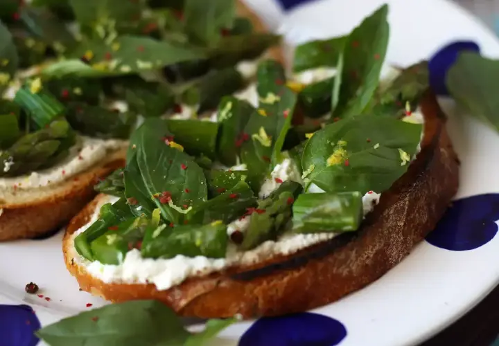 Krispigt rostat bröd med krämig ost, sparris och basilika. Ett perfekt bruschetta recept för en lätt lunch eller förrätt.