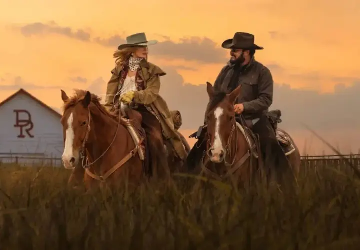 Deux cavaliers, Beth et Rip, sur leurs montures, devant une grange au coucher du soleil. Un aperçu du yellowstone saison 5 résumé.