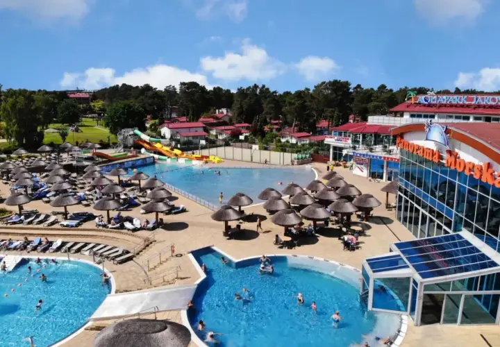 Hotel nad morzem z basenem all inclusive, zjeżdżalniami i mnóstwem leżaków pod parasolami.