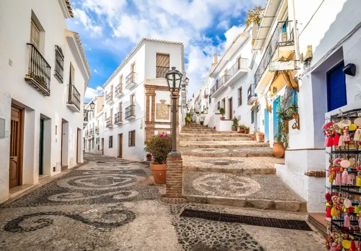 Calle empedrada con diseño de espirales, casas blancas y escalinata. Ideal para tu plan de qué ver en Andalucía en 7 días.