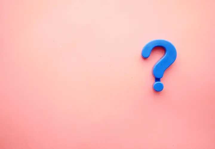 Niebieski znak zapytania, jeden z podstawowych znaków interpunkcyjnych po angielsku, na różowym tle.