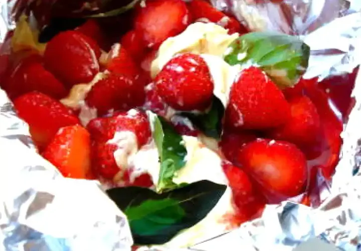 Fraises et crème dans du papier d'aluminium, un délicieux dessert pour barbecue.