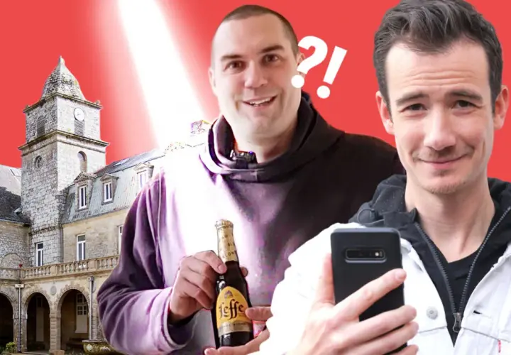 Deux hommes souriants devant un bâtiment historique, l'un tenant une bouteille de Leffe.
