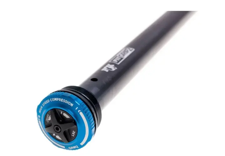 Close-up of a black bicycle suspension stanchion with a blue GRIP2 damper adjustment dial. The dial features "HIGH SPEED COMPRESSION" and "LSC" markings.