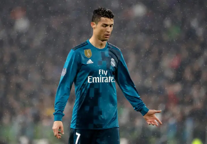 Piłkarz Cristiano Ronaldo w niebieskiej koszulce Realu Madryt, w deszczu. Ile hat tricków ma Ronaldo? Tego nie widać na zdjęciu.