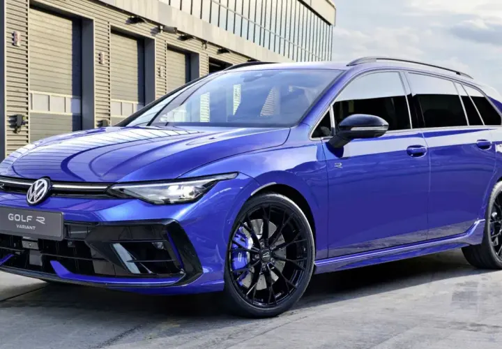 Niebieskie kombi auto Volkswagen Golf R Variant z czarnymi felgami i niebieskimi zaciskami hamulcowymi stoi przed nowoczesnym budynkiem.