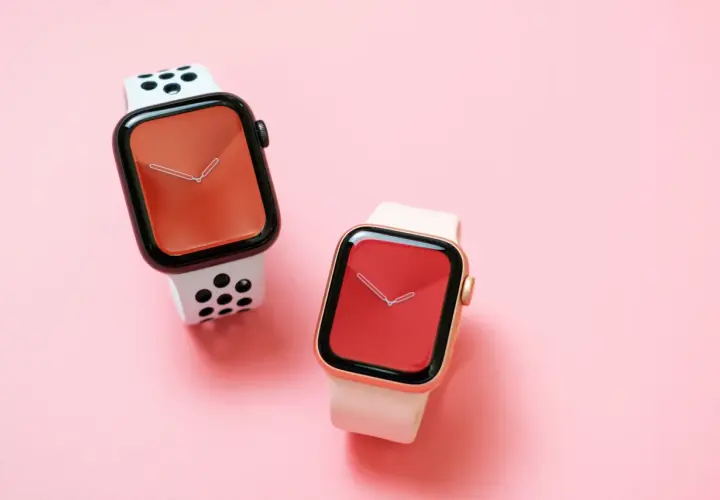 Dwa zegarki Apple Watch na różowym tle. Jeden z białym paskiem w czarne kropki, drugi z jasnoróżowym. Czas na wymiana baterii Apple Watch.