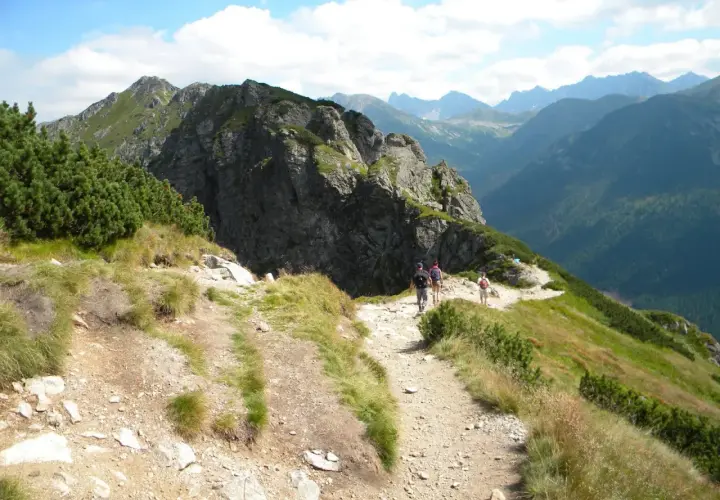 Grupa turystów wędruje malowniczym szlakiem w Tatrach. Widok na góry i doliny, idealne tatry szlaki dla średnio zaawansowanych.