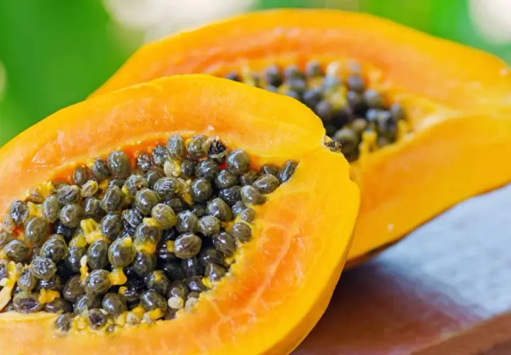 Zwei Hälften einer reifen Papaya mit vielen schwarzen Samen. Die Papaya ist bekannt für ihre verdauungsfördernde Papain-Wirkung.