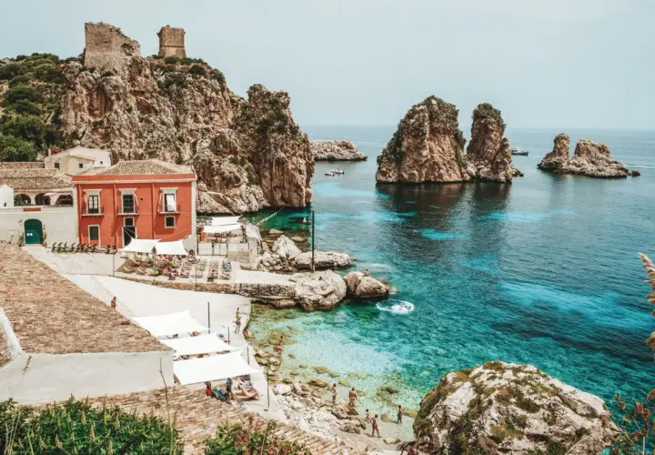 A picturesque cove with turquoise waters, rocky islets, and a charming village, this is a must-see among top places to visit in Sicily.