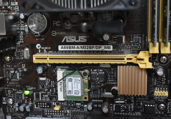 Carte mère ASUS A55BM-A/M32BF/DP_MB avec branchement carte mère visible, incluant une carte Wi-Fi et des connecteurs.
