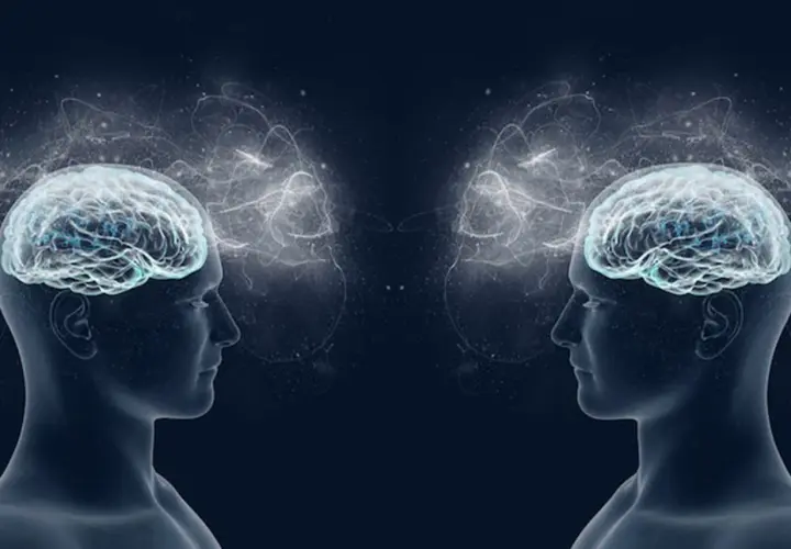 Due profili umani speculari con cervelli luminosi e connessioni eteree, che evocano i neuroni specchio e la comprensione empatica.