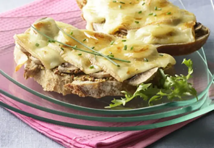 Tartines gourmandes avec une généreuse croute de fromage fondue, garnies de champignons et de ciboulette.