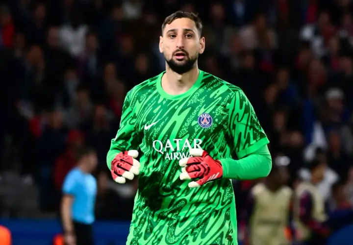 Gianluigi Donnarumma, bramkarz PSG, w zielonej koszulce i czerwonych rękawicach, gotowy do obrony.