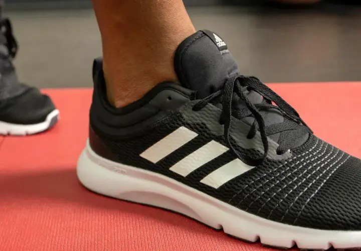 Czarne buty sportowe Adidas z białymi paskami, idealne do biegania. Poznaj różne rodzaje butów sportowych i ich nazwy.