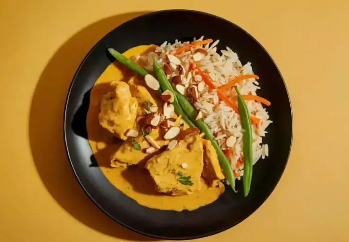 Aksamitny kurczak w sosie curry, podany z ryżem, fasolką szparagową i migdałami. Pyszne danie, które rozpływa się w ustach.