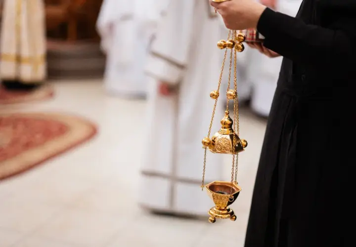 Złota kadzielnica w ręku osoby w czarnej szacie. Czy msza w środę popielcową jest obowiązkowa?