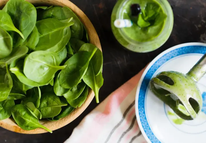 Świeży szpinak w misce, zielony koktajl i blender ręczny. Czy szpinak jest zdrowy? Tak, to superfood!