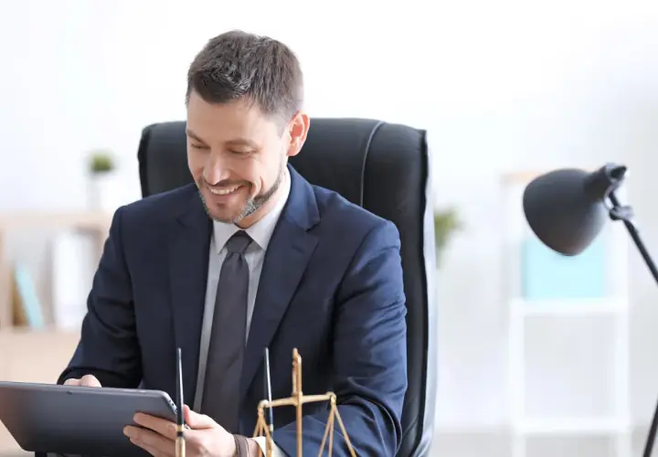 Un notaire souriant consulte une tablette, prêt pour un appel de fonds. La balance de la justice est visible.
