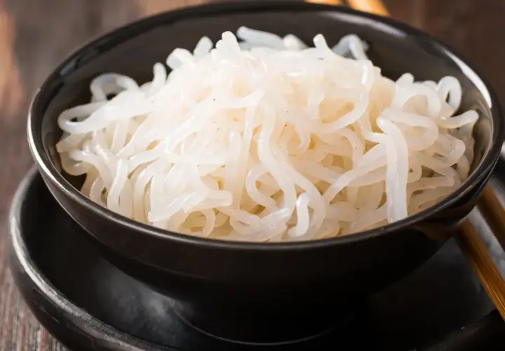 Misternie zwinięty makaron konjac w czarnej misce. To zdrowe i niskokaloryczne danie, które warto wypróbować.