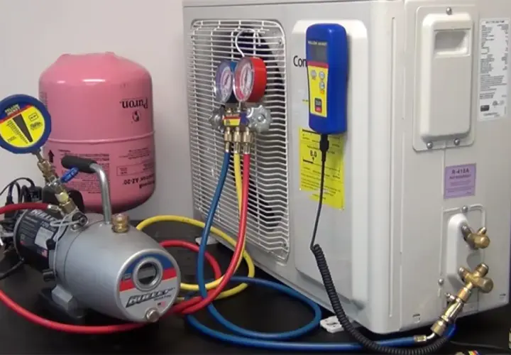 Equipo para hacer vacío a un aire acondicionado: bomba, manómetros, tanque de refrigerante y mangueras.