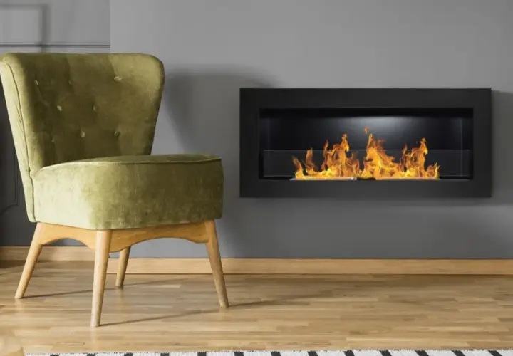 Sillón verde junto a una chimenea moderna con llamas danzantes. El humo de la chimenea crea un ambiente acogedor.