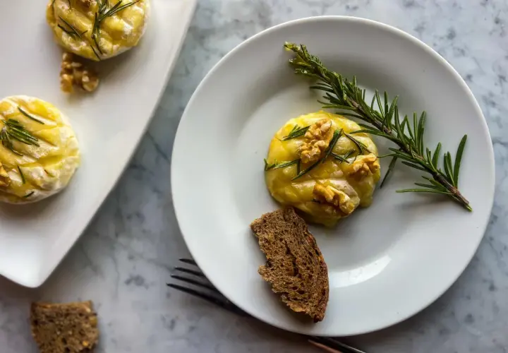 Deliziosi tomini in friggitrice ad aria, guarniti con noci e rosmarino, serviti con pane integrale.