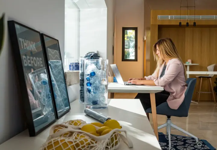Mujer trabajando en portátil con luz natural. La luz que entra por la ventana es ideal para la vista.