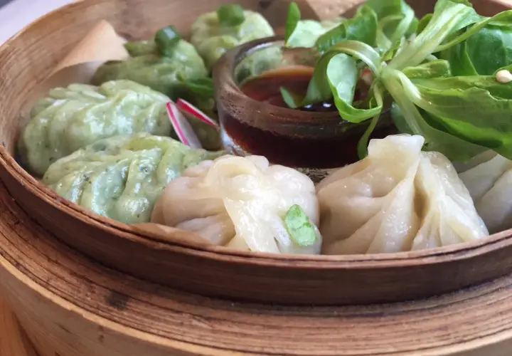 Parowóz z dim sum: zielone i białe pierożki z sosem i sałatką.