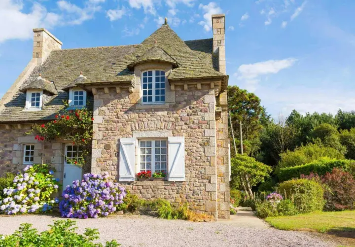 Charmante maison en pierre, fleuron d'un projet de cout renovation maison ancienne. Hydrangeas bleues et roses égaient l'entrée.