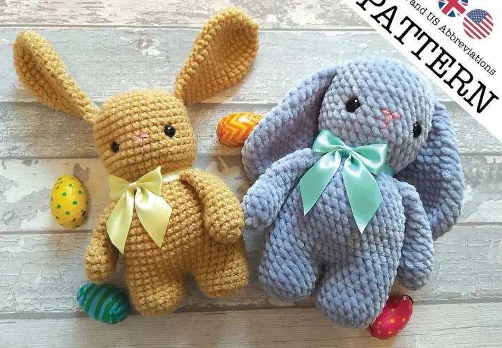 Due coniglietti amigurumi, uno color miele e uno azzurro, con fiocchi e uova di Pasqua.