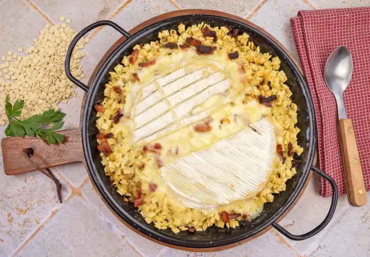 Une délicieuse crozet tartiflette, gratinée au fromage, avec des lardons et des crozets, prête à être dégustée.