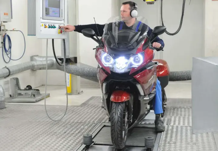 Mechanik sprawdza motocykl na hamowni. Regularny przegląd motocykla 125 zapewni jego sprawność.