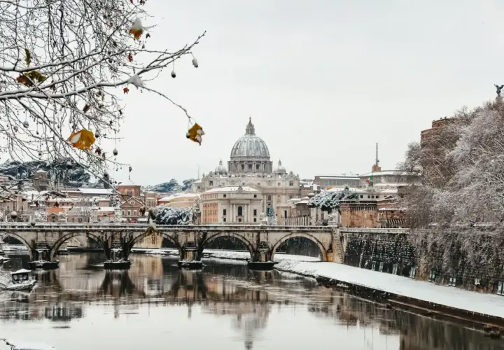 Un raro freddo a Roma imbianca il Tevere e i ponti, con San Pietro sullo sfondo.