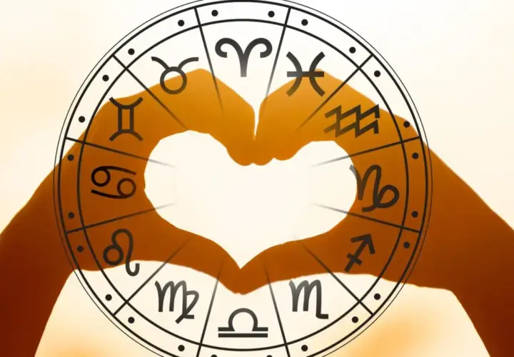 Dłonie tworzą serce na tle koła zodiaku, gdzie uran w koziorożcu symbolizuje przełom w dążeniu do celu.