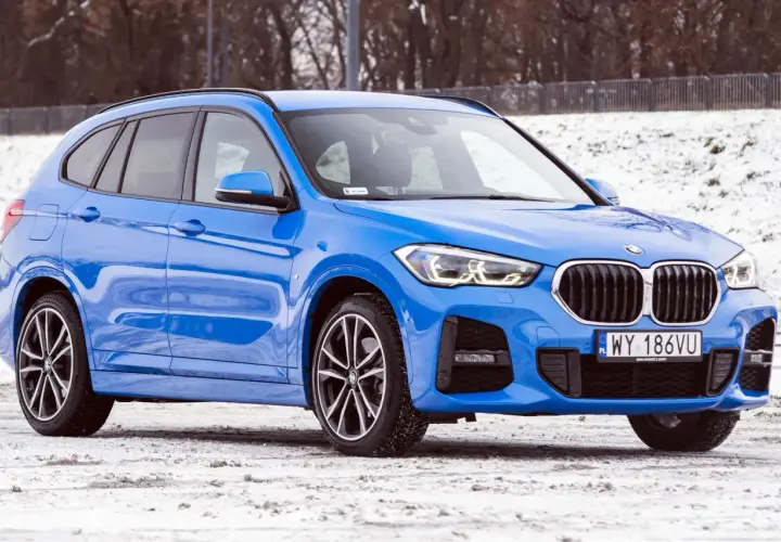 Błękitne BMW X1 2025 na śniegu, gotowe na zimowe wyzwania.