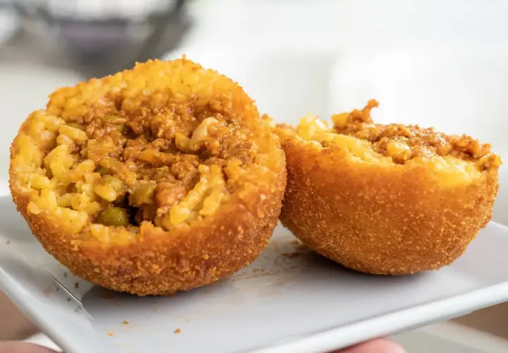 Arancini co to? Smażone kulki ryżowe z mięsem mielonym i groszkiem, chrupiące na zewnątrz, pyszne w środku.