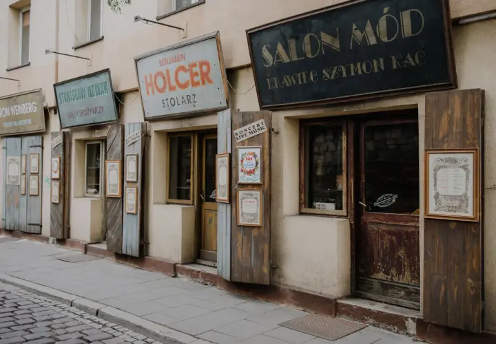Stare szyldy sklepów w krakowskim quartiere ebraico: "Salon Mód", "Holcer Stolaz", "Stanisław Nowak Sklep Spożywczy".