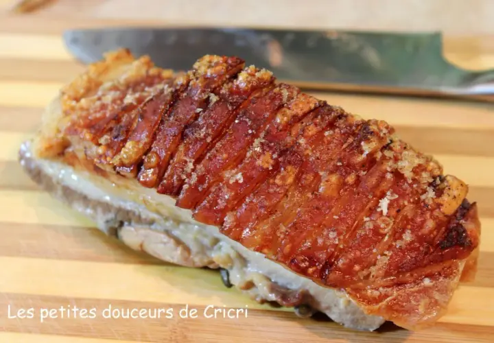 Un morceau de poitrine de porc croustillante, avec sa couenne dorée et craquante, prête à être dégustée.