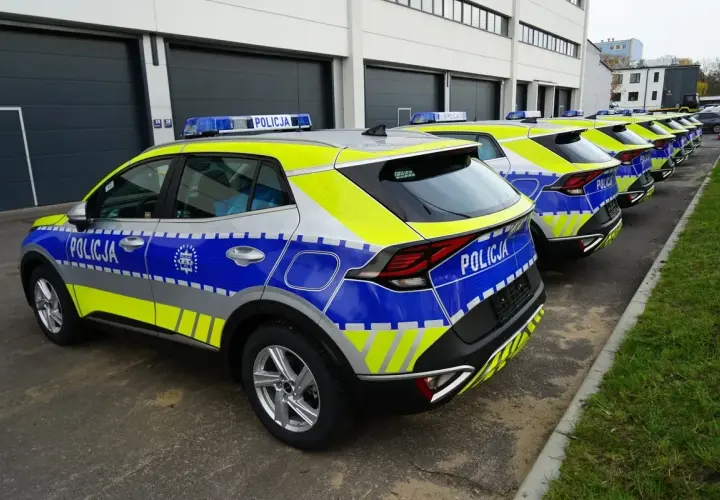 Nowe radiowozy z napisem POLICJA czekają na pra rejestracja. Błyszczące, nowoczesne pojazdy gotowe do służby.