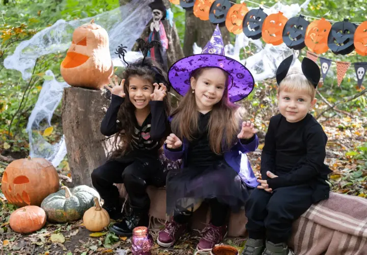 Niños disfrazados de esqueleto, bruja y ratón, listos para pedir dulces. ¡Así se divierten porque se disfrazan en Halloween!